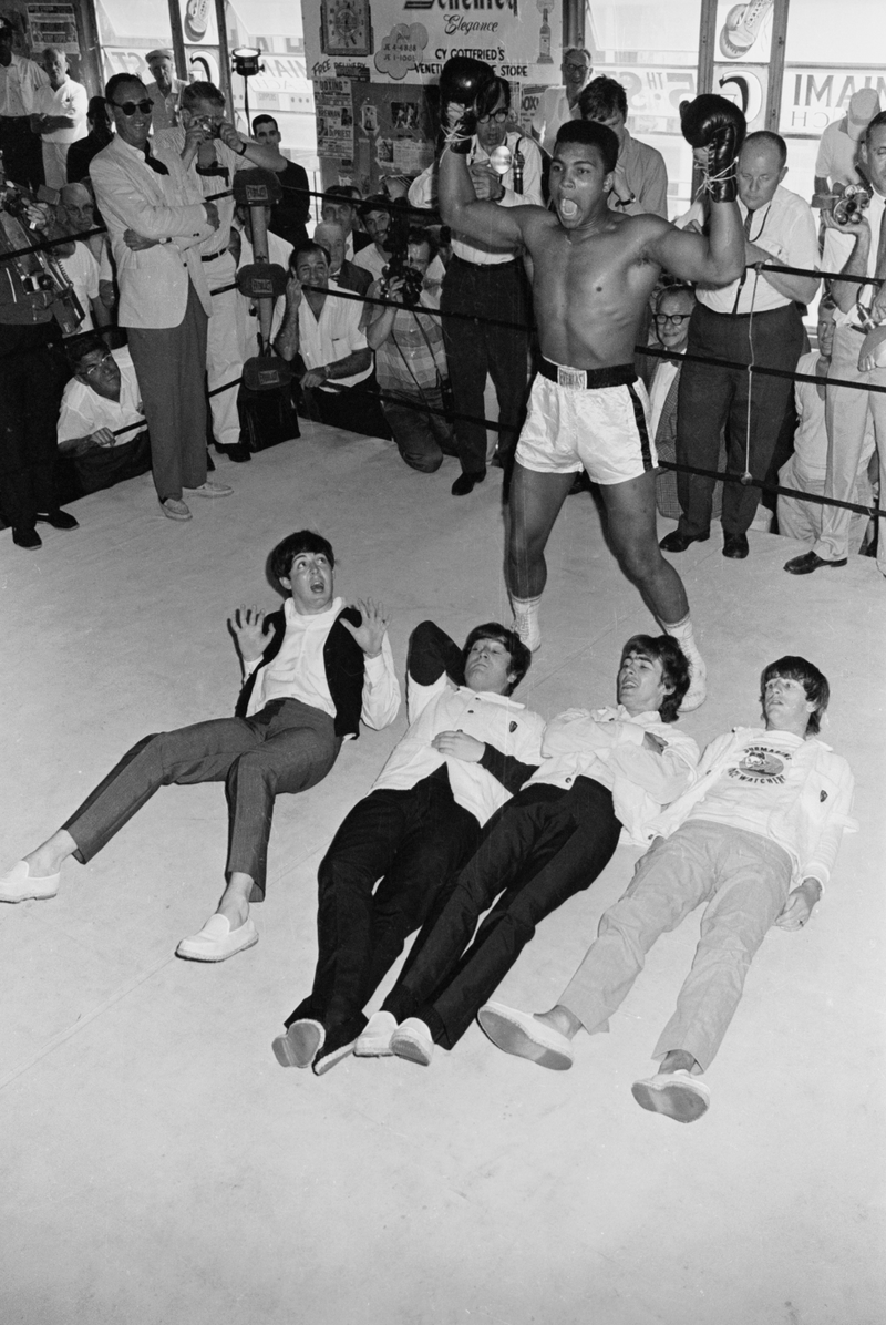 As Clay flays his chest "Tarzan Style" the Beatles are prostrate on the floor. The quintet clowned for photographers during a visit to the 5th street gym 2/18.Getty Images